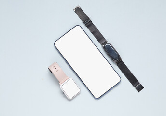 Smartphone and smart watch with white blank screens and smart bracelet on crescent background....
