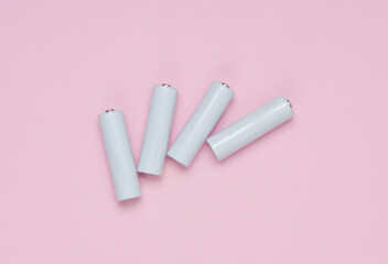 White blank aa batteries or accumulators on a blue-pink background. Mockup for design