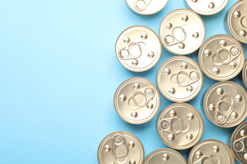 Cans with canned food on blue pastel background. Top view. Flat lay. Copy space