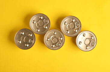 Cans with canned pet food on yellow background. Top view. Flat lay