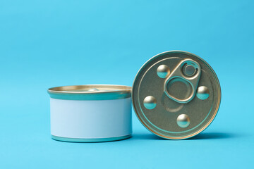 Tin cans of canned food with white labels on blue background, mockup for your design