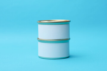 Tin cans of canned food with white labels on blue background, mockup for your design