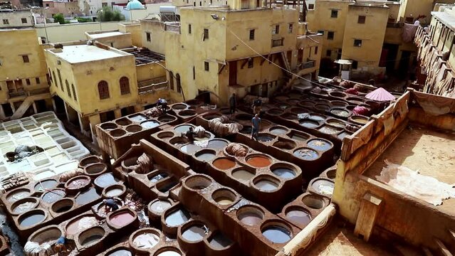 A man works in the Shuara leather dyeing factory. Traditional Moroccan craft. Morocco, Fez