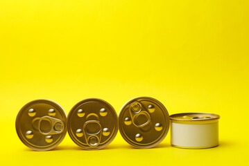Fototapeta premium Tin cans of canned food with white labels on yellow background, mockup for your design