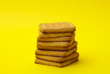 Stack of delicious cookies on yellow background