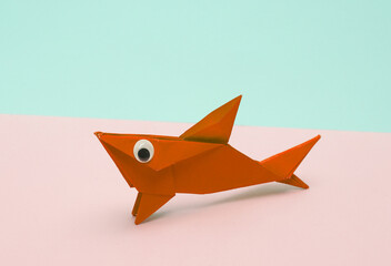 Red Origami shark with eyes on pink blue background. Creative layout
