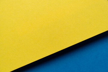 重なる黄色と青色の画用紙の背景