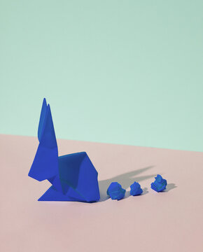 Origami rabbit on a blue-pink pastel background. Creative minimal layout.