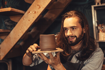clay cup mug handcrafted man artist happy working proud look at finished hand craft product ceramic tea mug art project at workshop