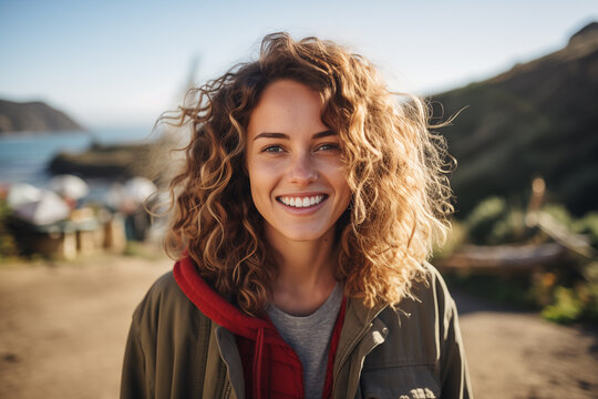 young woman looking at camera smile outdoor near the beach