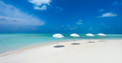 Summer tropical with white umbrella on the beach with  blue sky background