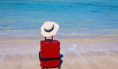 The Red luggage on the beach- summer travel concept