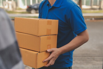 Asian delivery express courier young man use giving boxes to woman customer he wearing protective...