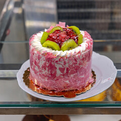 Pink Cake Topped With Red Berry Fruits and Kiwi