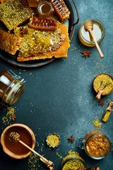  Honey banner. Honeycombs, honey in jars and flower pollen. On a black stone background © Yaruniv-Studio