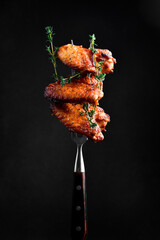 Traditional Buffalo BBQ chicken wings, on a fork. On a black background. - 788117125