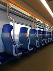 Interior of a train with seats in blue and orange colors.