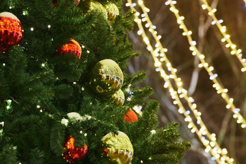 New Year christmas tree decorated Christmas balls with yellow flickering lights of garlands copy space, merry Christmas and happy New Year mood at twinkling lights of decorations