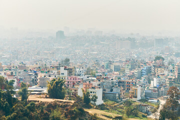 View of Kathmandu capital of Nepal from mountain through urban haze with lot of low rise buildings,...