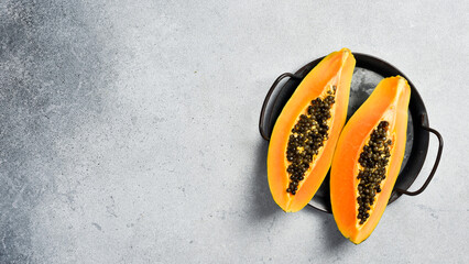 Close up of exotic papaya fruit. Sliced papaya on a gray concrete background. - 788118341