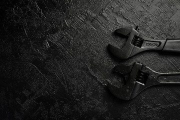 Spanner on a black stone background. Concept of repair or adjustment.