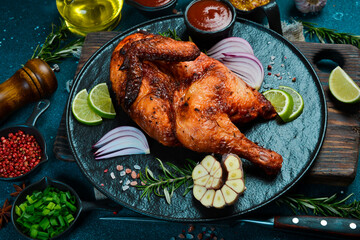 Baked chicken or turkey with rosemary, lemon and spices on a black stone plate. Traditional festive dish. - 788118955