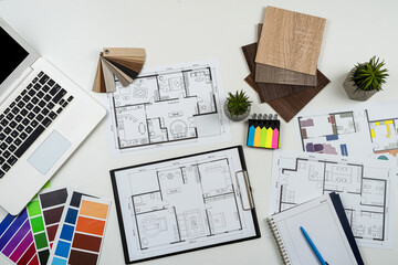 Interior designer's working table with laptop tools wooden color sampler and blueprints of the...