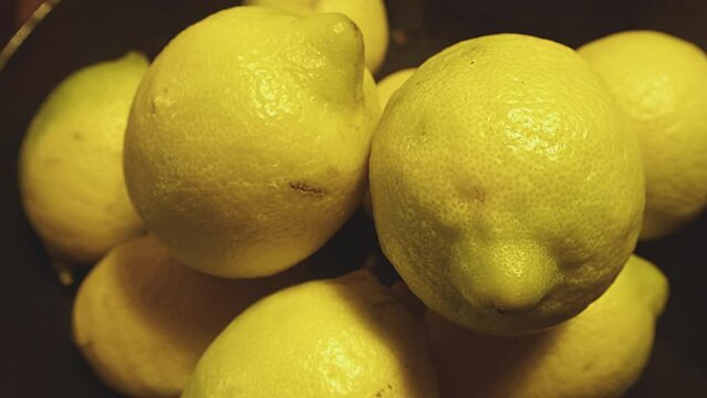 Indoor, slow motion, whole fruit lemons close up, macro. Yellow citrus fruits detail. Studio shot. Kitchen. High quality 4k footage