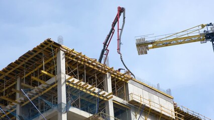 Workers pour concrete at the construction site of a new residential building