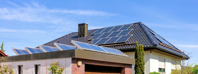 Modernes Wohnhaus und Garage mit Solaranlagen zur umweltfreundlichen Strom- und Warmwassererzeugung - obrazy, fototapety, plakaty