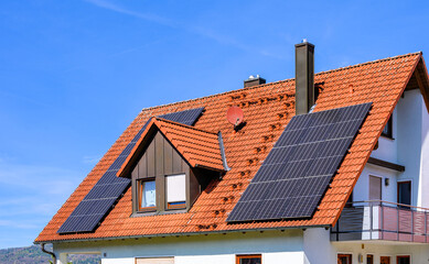 Solaranlage zur eigenen Stromerzeugung auf rotem Einfamilienhaus