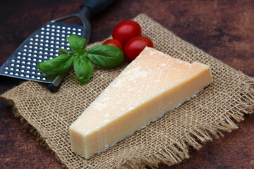 A piece of parmesan cheese with tomato and basil.