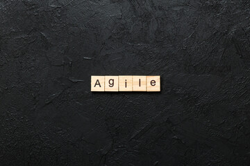 Agile word written on wood block. Agile text on cement table for your desing, concept