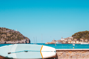 A captivating image captures a paddle surfboard against the backdrop of a serene blue sea. The...