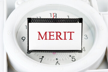 Business and merit concept. MERIT written on a white business card