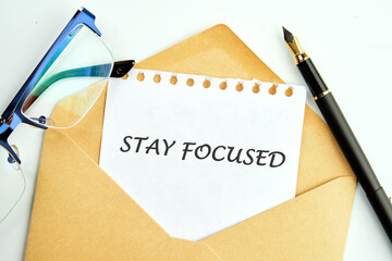 Motivation concept. STAY FOCUSED written on a sheet in an envelope