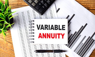 VARIABLE ANNUITY text on notebook on chart with calculator and pen