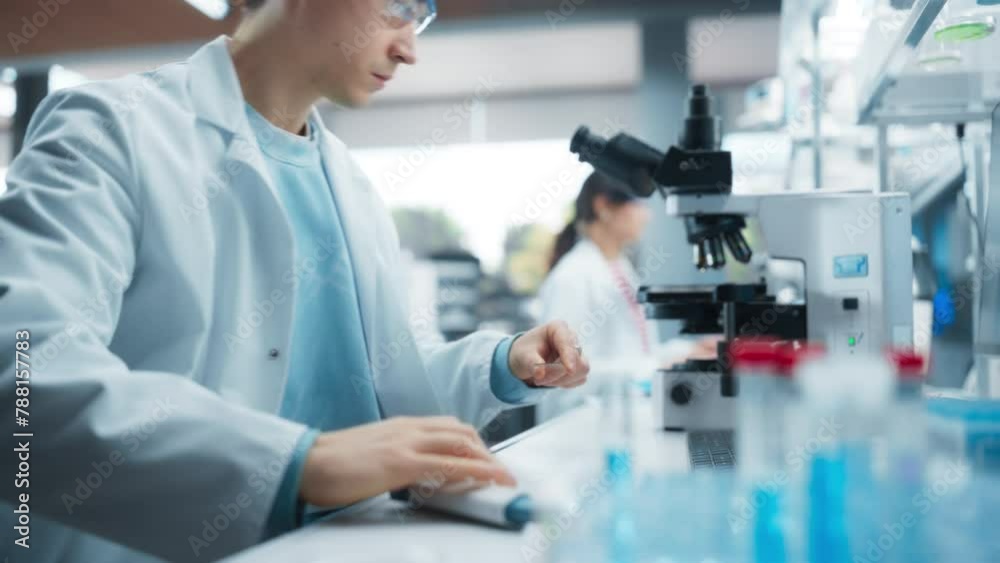 Poster medical research laboratory: portrait of a handsome scientist using micropipette to analyze samples 