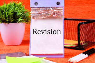 Revision word It is written on a desktop calendar with loose leaves
