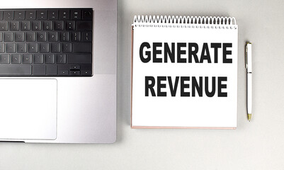 GENERATE REVENUE text on notebook with laptop and pen