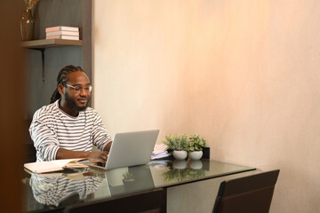 Young African American male entrepreneur using laptop working from home