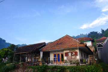 A classic model house in the countryside with a hill in the background, in the morning, stock photo.