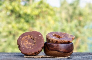 Khejur Gur or Date Palm Jaggery in a Wooden Bowl and Palm Jaggery on Burlap Fabric Isolated on Wooden Table with Natural Background with Copy Space
