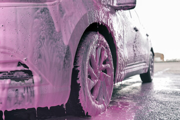 Hand washing car with pink foam, advertising