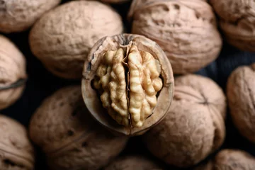  Cracked walnut with kernels on heap of whole walnuts close up. Food photography © Ivan Kmit