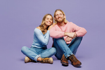 Full body young smiling fun couple two friends family man woman wear pink blue casual clothes together sitting hug cuddle look camera isolated on pastel plain light purple background studio portrait