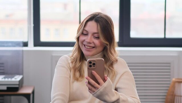 Positive Caucasian woman spending leisure time with telephone at home, resting on sofa during weekend. Online entertainment and internet messaging concept.