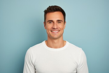 Obraz premium Portrait of a cheerful man in his 30s sporting a long-sleeved thermal undershirt over solid color backdrop
