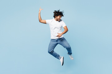 Full body young happy fun Indian man he wears white t-shirt casual clothes jump high play air...