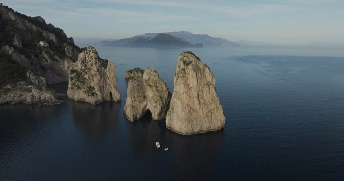Aerial view of Faraglioni rock formation and blue water, Capri Island, Italy.